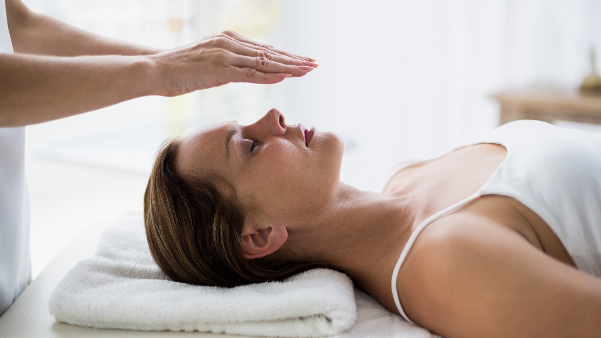 Abgeschnittene Hände eines Therapeuten, der Reiki an einer Frau macht
